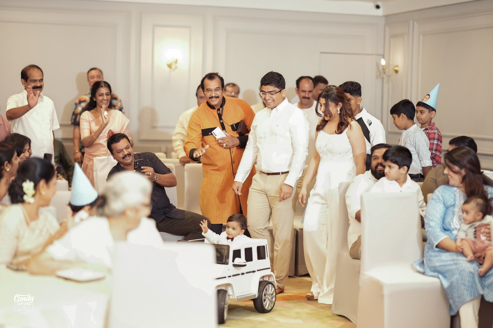 A baby arriving at a birthday celebration with family