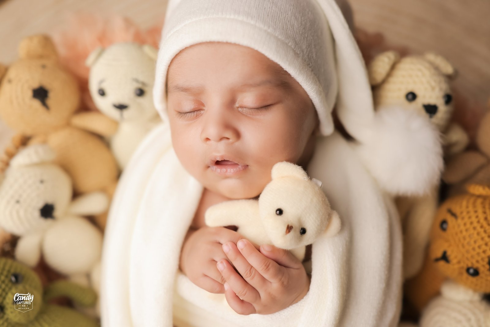 Close portrait of a sleeping newborn with a tiny teddy